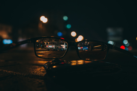 Night cityscape with skyscrapers and city lights as seen through a pair of glasses. Blurred image. bokeh. Night cityの写真素材