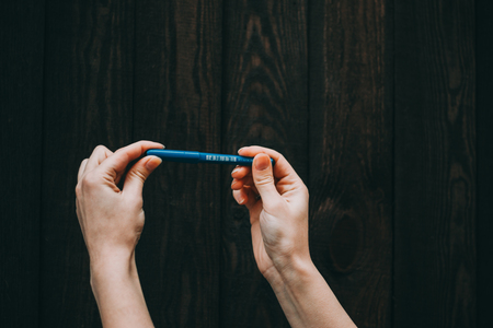 hands with pencil and erase rubber writting something on a wooden backgroundの写真素材