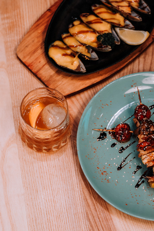 mussel with parsley leaf isolated on table with coctail and kebabの写真素材