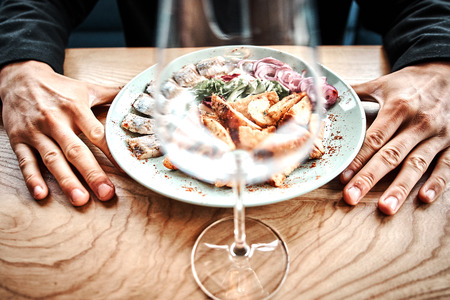 Chef finishing her plate and almost ready to serve at the table. Only hands. Finally dish dressing: steak meat, fishの写真素材