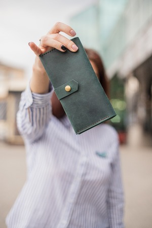 Sky blue handbag purse and beautiful woman hand with manicure. blurred backgroundの写真素材