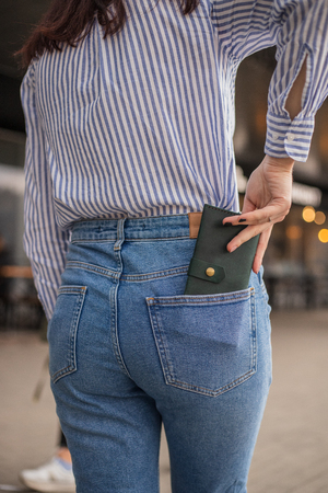Confident woman posing in save keeping your wallet in the back pocket in pantsの写真素材