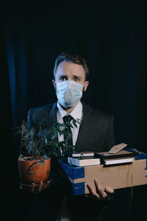 Fired business man in a mask lost his job because of COVIDの写真素材