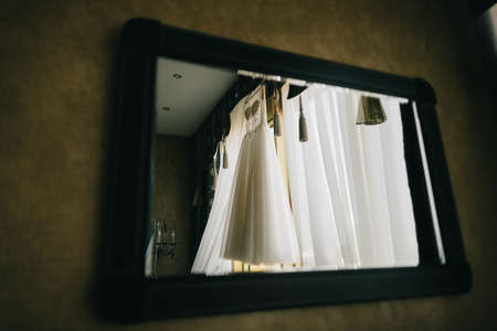 wedding dress reflect in a mirror in gold lightの写真素材