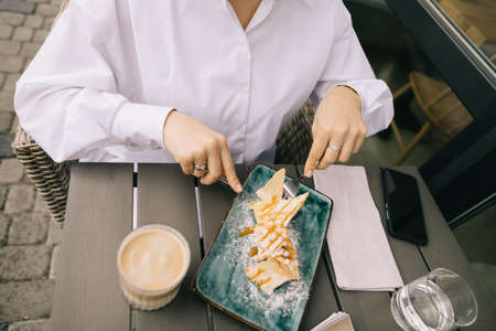 top view of how a girl eats a cake and drinks coffee with glasses and a fashion magazine on the backgroundの写真素材