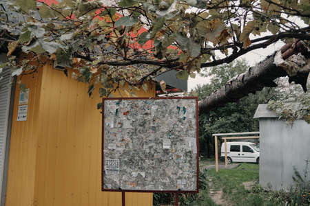 Ukrainian bulletin board on the background of a house and a car with a tree on topの写真素材
