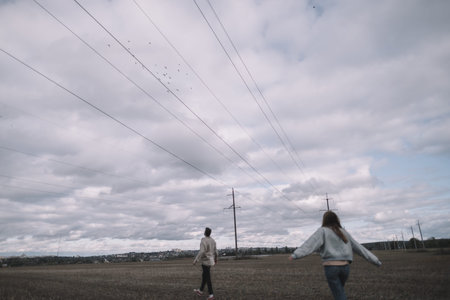 a couple in love walks in an open soybean field in the evening in cloudy weather and hugs a lot