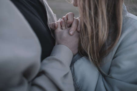 a couple in love walks in an open soybean field in the evening in cloudy weather and hugs a lotの写真素材