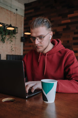 Portrait of happy male freelancer in optical eyewear for vision correction smiling at camera during...