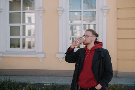 Takeaway coffee is my lifestyle. Handsome man hold coffee cup outdoors. Young guy drink coffee on...