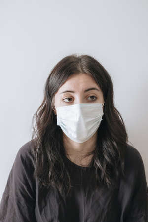 health care and pandemic concept. Asian woman in black t-shirt and medical mask and looking sad and disappointed at camera.の写真素材