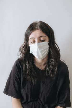health care and pandemic concept. Asian woman in black t-shirt and medical mask and looking sad and disappointed at camera.の写真素材