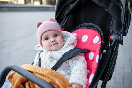 Baby in stroller on a walk in summer park. Adorable little boy in checkered shirt sitting in blue...