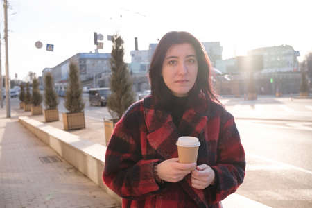Woman drinking coffee in the sun, outdoor in sunlight light, enjoying her morning coffee.の写真素材