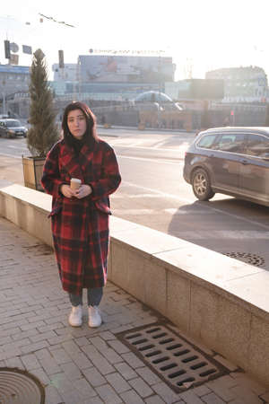 Woman drinking coffee in the sun, outdoor in sunlight light, enjoying her morning coffee.の写真素材
