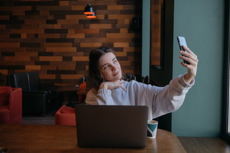 Smiling woman sitting on kitchen sofa talking by videocall dating online looking at phone. Video...