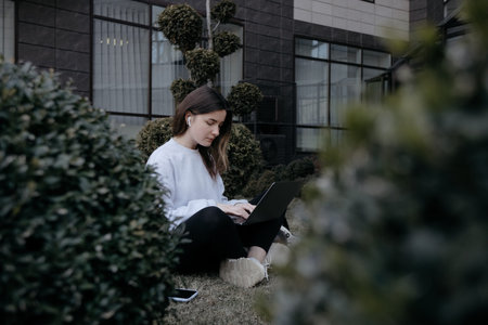 Workation outdoor. Woman working on laptop in park. Distant remote job work during quarantine virus