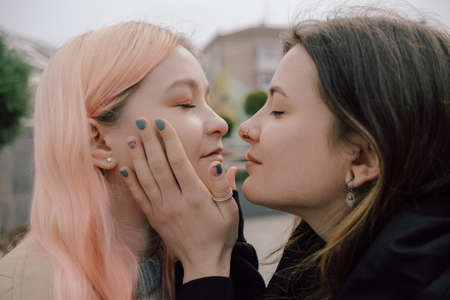 Happy young lesbian couple look on each other with love in their eyesの写真素材