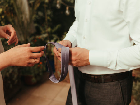 bride helps groom to wear a tie grain effect