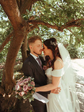 Happy wedding couple walking in a botanical park grain effect authenticの写真素材