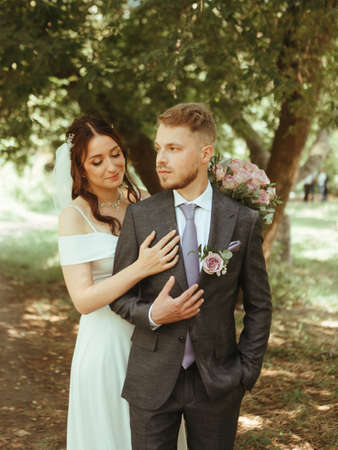 Happy wedding couple walking in a botanical park grain effect authenticの写真素材