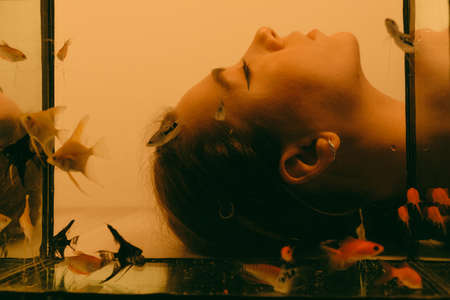 porrait of woman underwater with fish conceptの写真素材