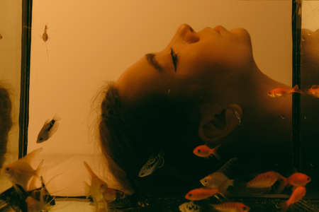 porrait of woman underwater with fish conceptの写真素材