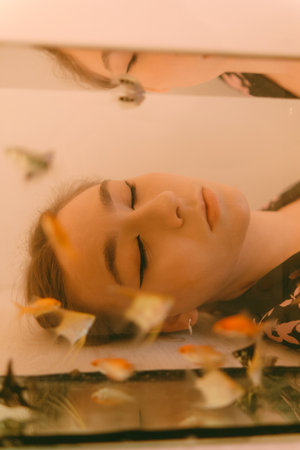 porrait of woman underwater with fish conceptの写真素材