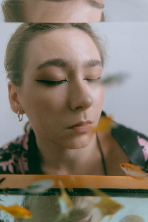 porrait of woman underwater with fish conceptの写真素材