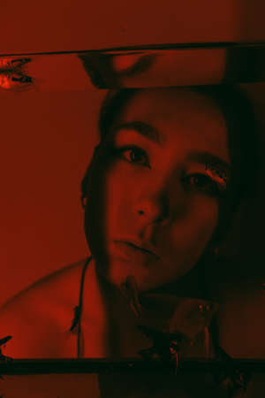 porrait of woman underwater with fish concept red lightの写真素材