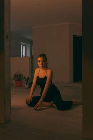 portrait of woman at home during renovation. dark. spot light on the modelの写真素材