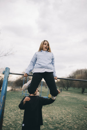 man and woman having fun on the playground in the parkの写真素材