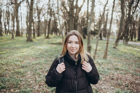 woman traveler with backpack and looking at amazing forest, wanderlust travel concept, space for text, atmospheric epic momentの写真素材