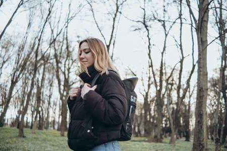 woman traveler with backpack and looking at amazing forest, wanderlust travel concept, space for text, atmospheric epic momentの写真素材