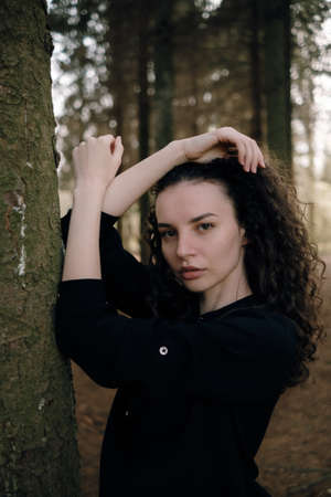 portrait of curly brunette womanin the parkの写真素材