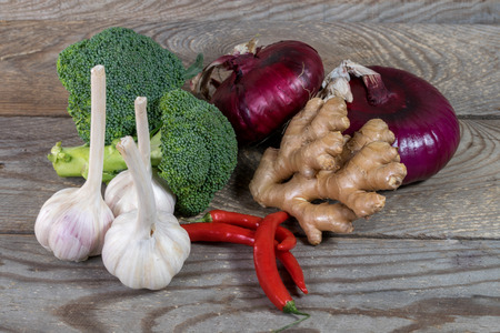 Fresh garlic, broccoli, onion, chili pepper, ginger on vintage wooden backgroundの写真素材