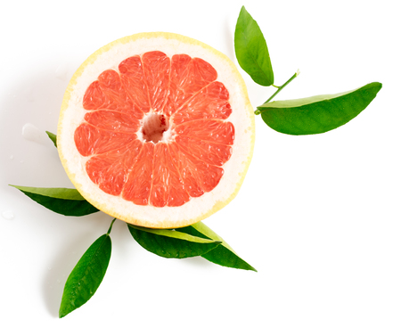 Slice of ripe grapefruit with leaves isolated on white backgroundの写真素材
