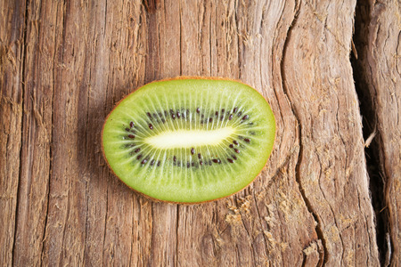 Fresh green kiwi slice isolated on wooden backgroundの写真素材