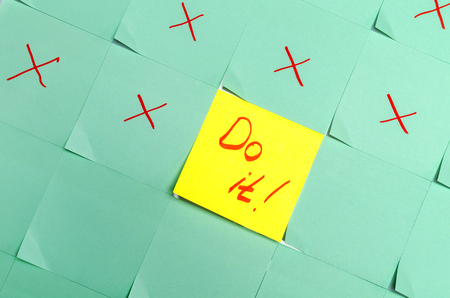 Yellow sticker with the inscription "Do it!" lies between green stickers.の写真素材