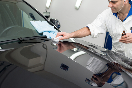 Man on a car wash polishing car with a polish machineの写真素材