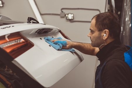 Man on a car wash polishing car with a polish machineの写真素材