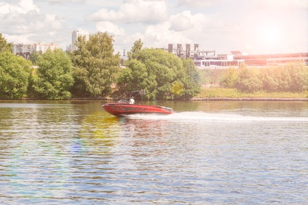 A beautiful golden sunset on the river. Lovers ride in a boat on a lake during a beautiful sunset.の写真素材