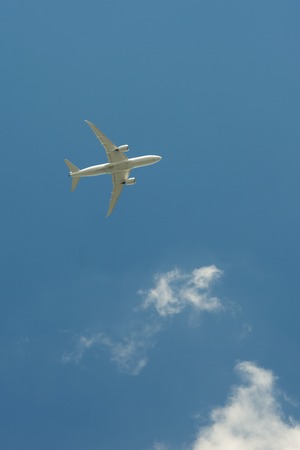 Airplane flying against the blue skyの写真素材