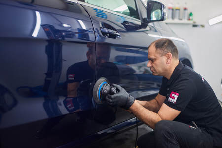 Moscow. Russia. May 30, 2018. A man polishes a blue Mercedes car ml.のeditorial素材