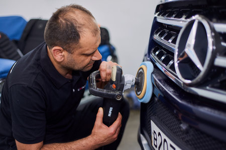 Moscow. Russia. May 29, 2018. A man polishes a blue Mercedes car ml.