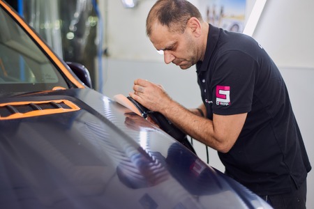 Moscow. Russia. May 29, 2018. A man polishes a blue Mercedes car ml.のeditorial素材