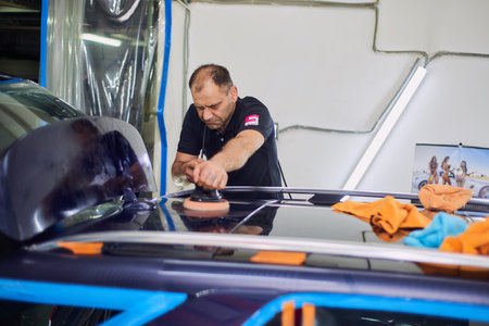 Moscow. Russia. May 29, 2018. A man polishes a blue Mercedes car ml.のeditorial素材