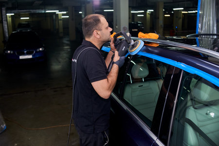 Moscow. Russia. May 29, 2018. A man polishes a blue Mercedes car ml.
