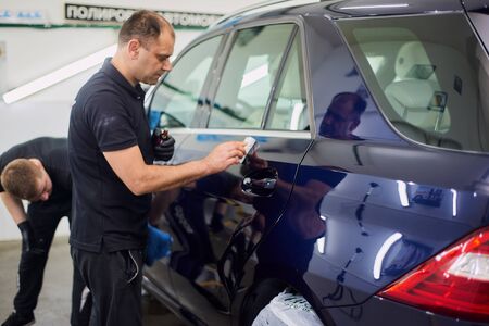 Moscow. Russia. May 29, 2018. A man polishes a blue Mercedes car ml.のeditorial素材