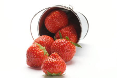 Ripe Strawberry Scattered from Tin Bucket isolated on white backgroundの写真素材
